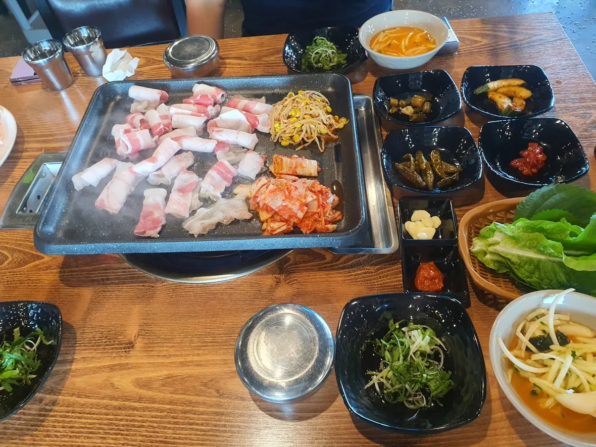 낙원돈대패의 불판 위 대패삼겹살과 반찬