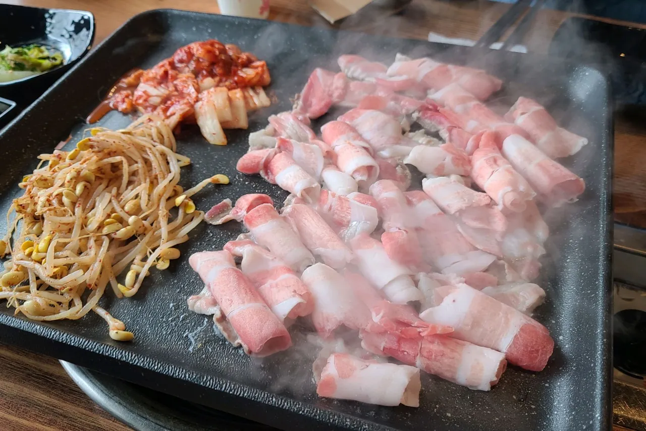낙원돈대패의 대패삼겹살이 불판 위에서 구워지는 모습