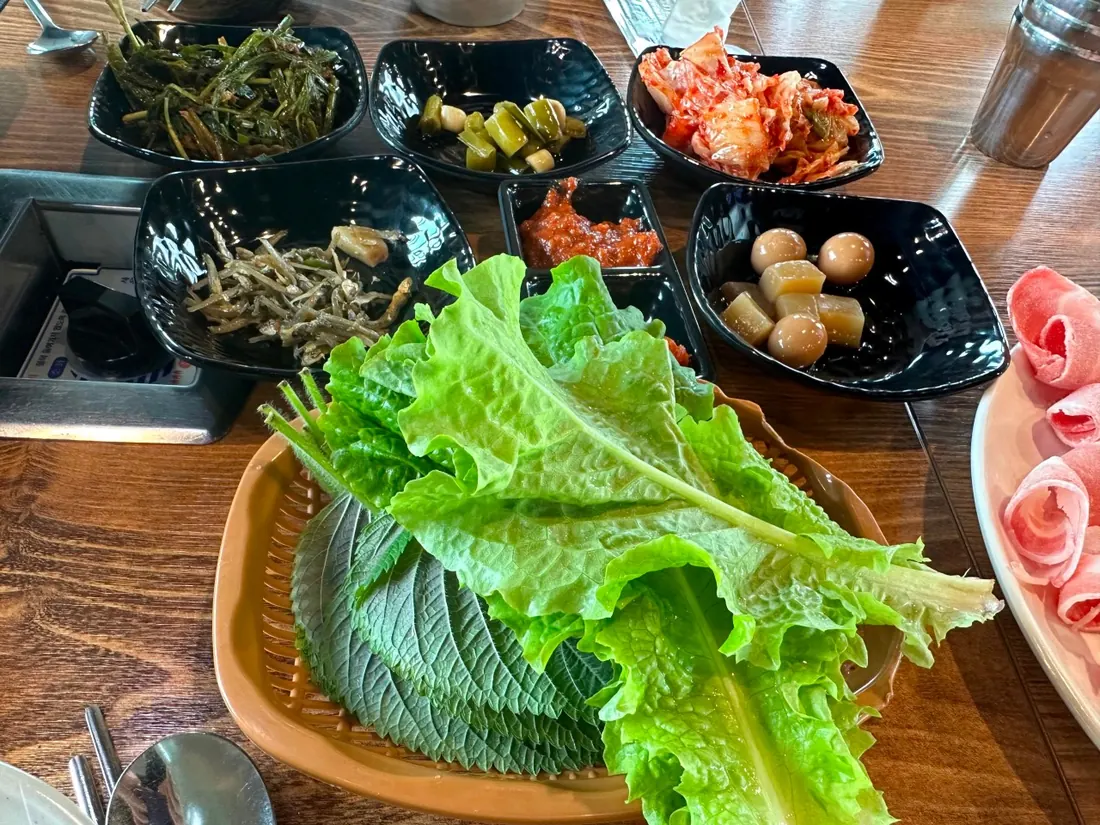 상추·반찬과 대패삼겹살이 차려진 낙원돈대패 식탁